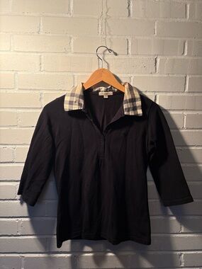 Black polo with iconic Nova check collar Size S